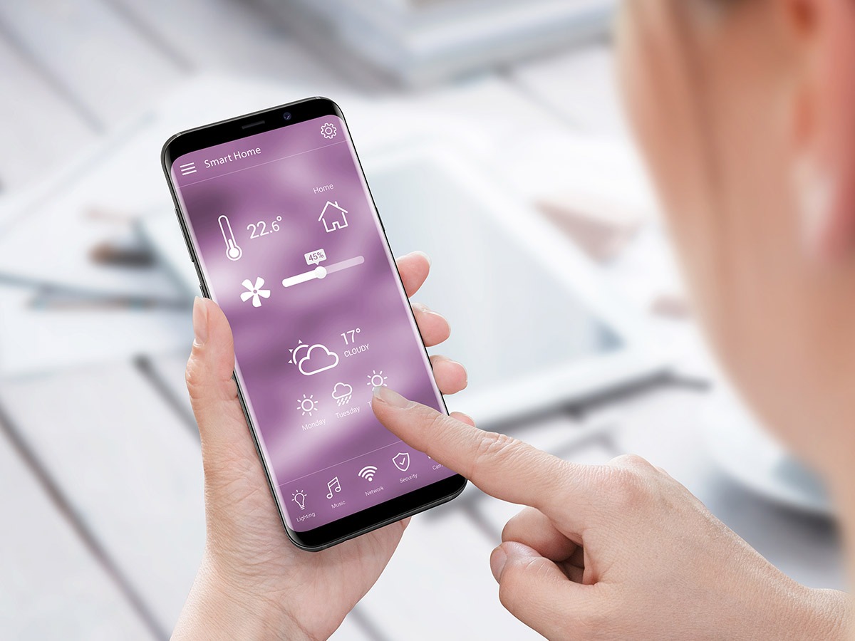 Woman adjusting her smart home from her smartphone.