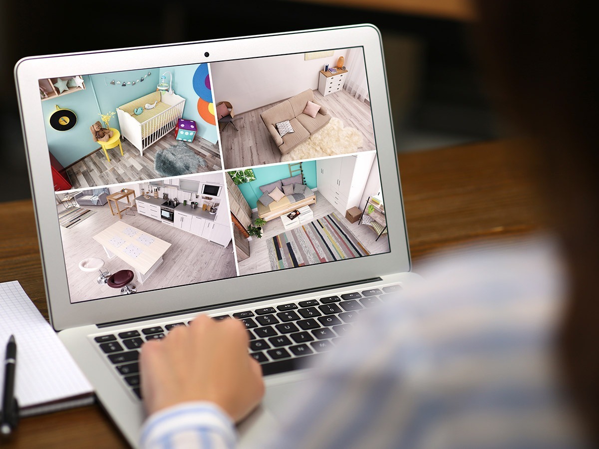 Woman checkin in on her home cameras from a laptop computer.