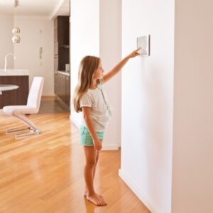 child adjusting smar thermostat