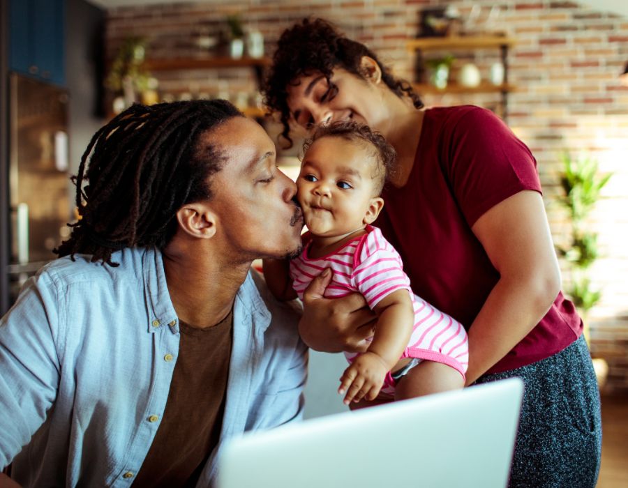 man with wife and child working on a computer