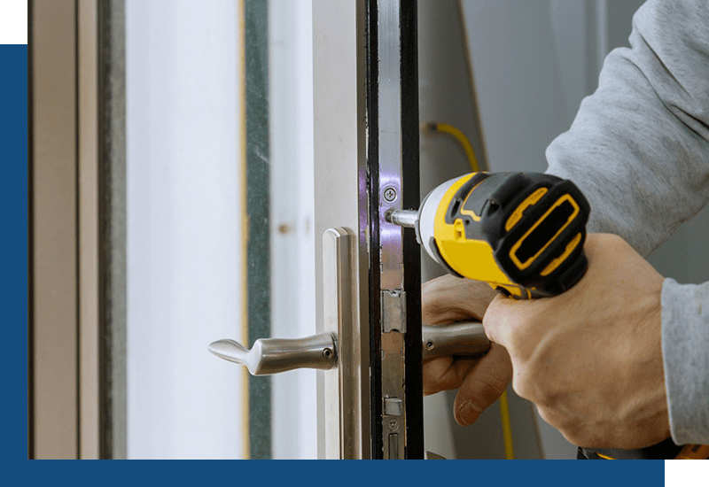 Locksmith installing a lock in a door