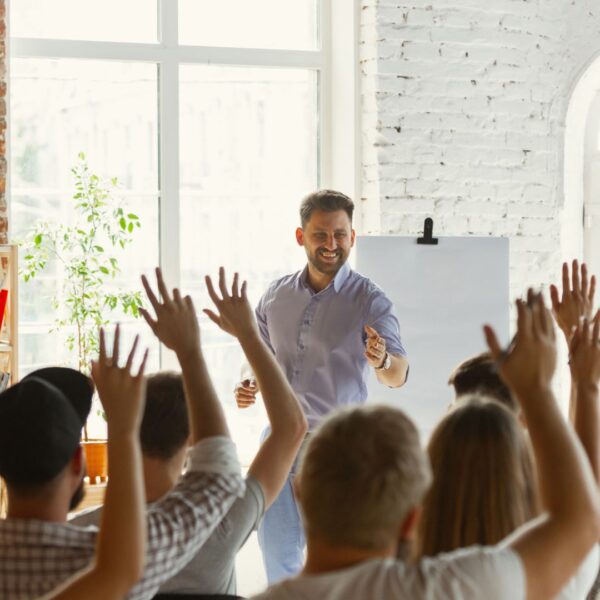 employees raising hands in training session
